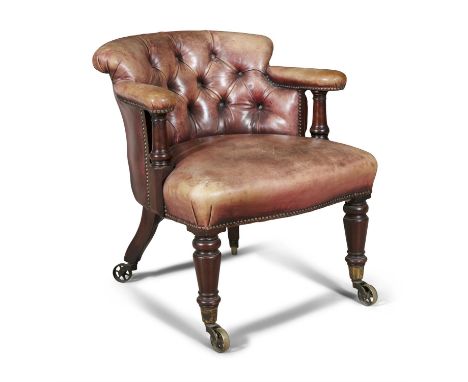 AN EARLY VICTORIAN DEEP TUB BACK CHAIR,upholstered in button back leather, supported on turned tapering legs, with brass whee