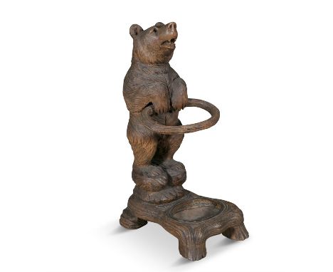 A SWISS CARVED LINDEN WOOD BEAR-CUB STICK STAND, LATE 19TH CENTURY Black Forest, 87cm high.Provenance: Kilternan Grange, Co. 