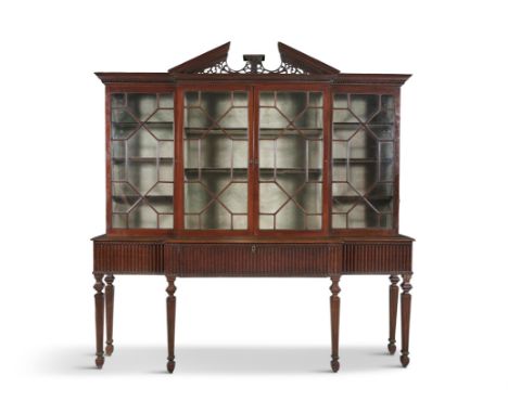 AN IRISH GEORGE III FOUR DOOR BREAKFRONT BOOKCASE, surmounted with pierced architectural pediment above astragal glazed doors