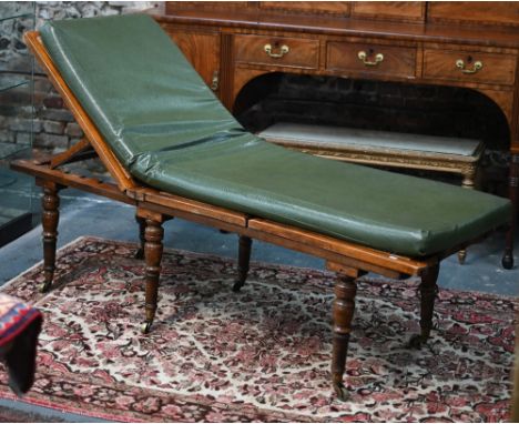 A Victorian cane panelled campaign day bed, raised on turned legs to brass castors, with green leatherette cushion - some dam
