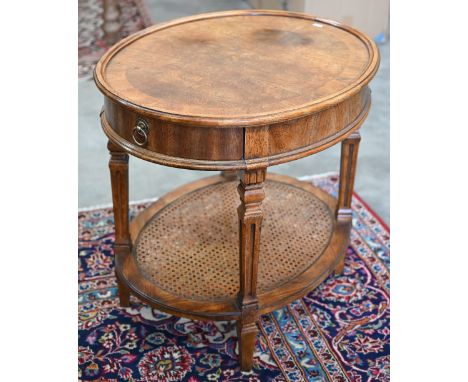A French Louis XVI style oval side table with single drawer, tapering supports and caned under-tier, 70 x 56 x 64 cm h