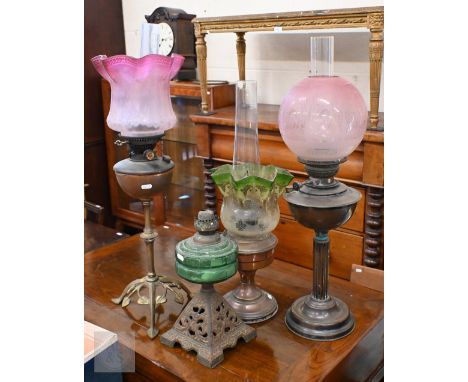 An Art Nouveau brass oil lamp with etched pink glass shade to/w three other oil lamps (4) 