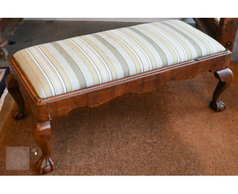 A 19th century mahogany framed stool on carved supports with ball and claw feet, green striped upholstery, 90 x 40 x 35 cm