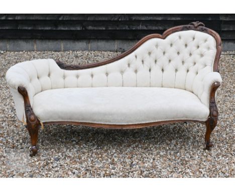 A Victorian carved mahogany framed chair-end chaise longue with damask button back upholstery, shaped legs and brass casters,