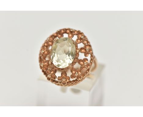 A 9CT GOLD GEM SET RING, set with an oval cut pale green stone assessed as spinel, in a four claw setting, within an openwork