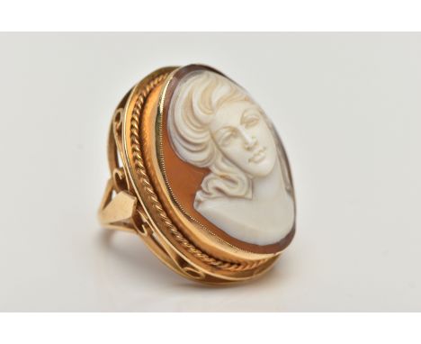 A LARGE 9CT GOLD CAMEO DRESS RING, oval shell cameo depicting a lady, collet set with a fine rope twist surround, ring head m