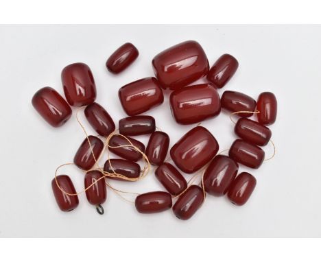 A SMALL BAG OF LOOSE CHERRY AMBER BAKELITE BARREL BEADS, graduated oval beads, visible swirls inside, largest measuring appro