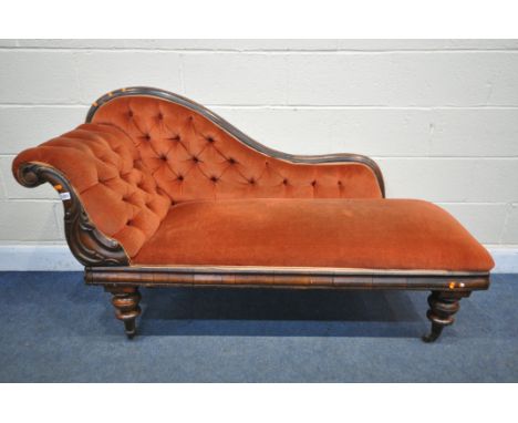 A VICTORIAN MAHOGANY CHAISE LONGUE, with red buttoned fabric, on turned legs and ceramic casters, Length 164cm (condition:- r