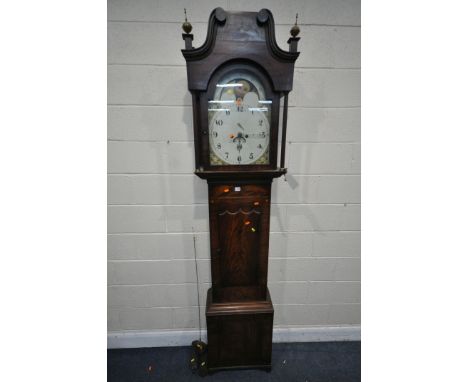 A GEORGIAN MAHOGANY 8 DAY LONG CASE CLOCK, the hood with brass finials over reeded pillars, flanking a glazed door that's enc