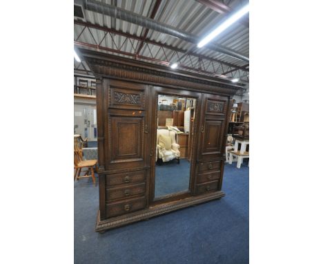 AN EARLY 20TH CENTURY HAMPTON AND SONS OF PALL MALL EAST LONDON, CARVED OAK COMPACTUM WARDROBE, comprising fielded panel door