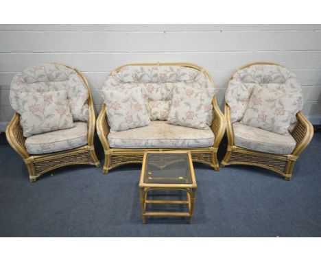 A WICKER CONSERVATORY SUITE, comprising  a sofa, two armchairs, pouffe, and a coffee table (condition:- worn and damaged fini