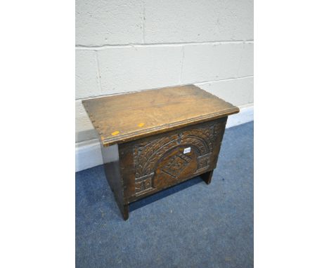 A REPRODUCTION OAK PANEL CHEST, with a carved front, width 56cm x depth x 34cm x height 44cm (condition:- aged wear and tear)