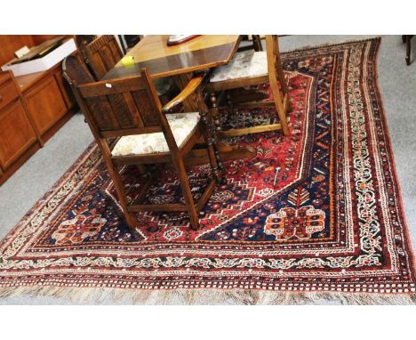 Kashgai Carpet, the raspberry lozenge field with three stepped medallions, framed by spandrels and meandering vine borders, 3