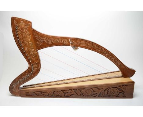 A hardwood Celtic harp with decorative floral carved sides, and Celtic style ivorine inlay, spruce soundboard, soft case.