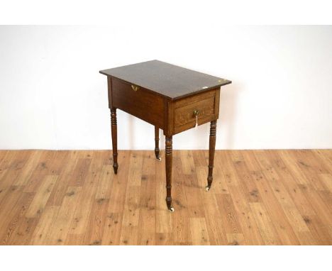 A 19th Century oak side table, the flared top over a single drawer to the frieze, raised on turned supports and ceramic casto