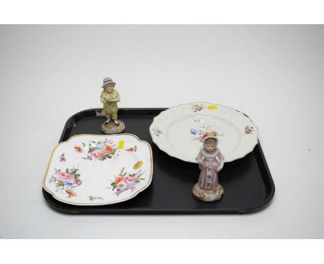A pair of Continental ceramic figures of children, modelled as a boy reading and a girl holding a hand fan, each with blue an
