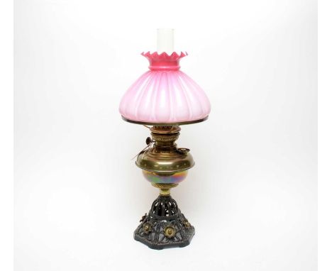A 19th Century brass oil lamp, with brass reservoir over pierced and moulded foliate base, applied SP Catterson London makers