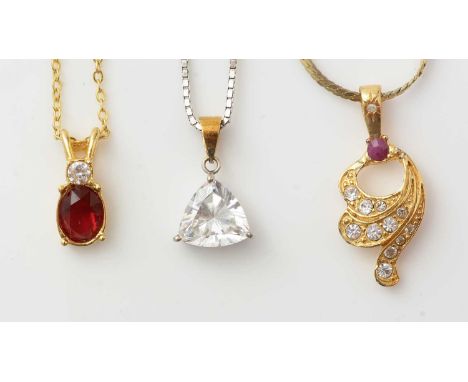 A ruby diamond and white stone pendant; a white stone pendant; and another. 