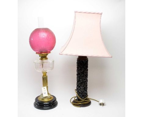 A Victorian brass oil lamp, with clear glass reservoir and cranberry glass shade, 66cms high including funnel; together with 