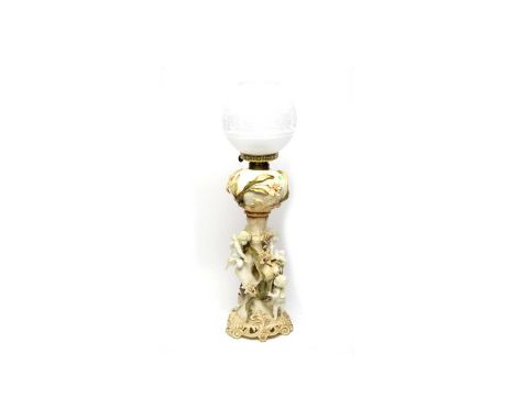 A Moore brothers oil lamp, with globular reservoir, applied with putti and flowering lilies, scroll moulded base, with etched