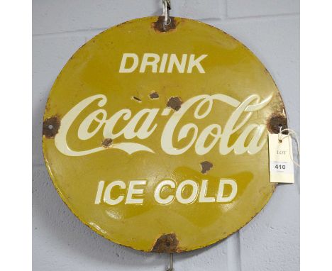 A Coca Cola enamel advertising sign, of circular form, inscribed ‘Drink Coca-Cola Ice Cold’, 35.5cms diameter. 