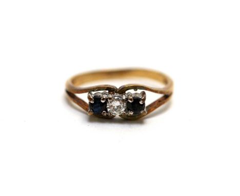 A sapphire and diamond three-stone ring, the central round brilliant cut diamond approximately 0.10 carats, flanked by round 