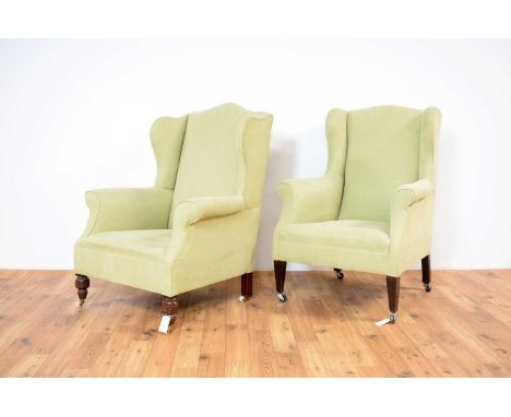 Two 19th Century wingback armchairs upholstered in light green fabric, arched headrests, with scrolled armrests and cushioned