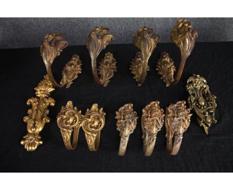 A collection of nine baroque style brass curtain (set of four, a pair and three) tie backs, a door knocker and one gilt wood 