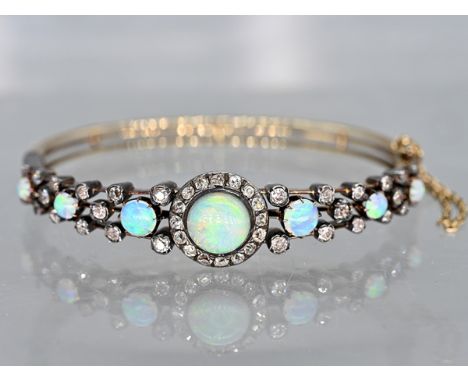 Armreifen mit 7 hochfeinen Opal-Cabochons, zus. ca. 2,7 ct, und 44 Altschliff-Diamanten, zus. ca. 1,25 ct, um 1900 585/- Gelb