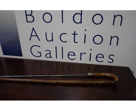 A late Victorian sword stick, having single fullard blade, silver plated ferrules and knotted wood shaft.