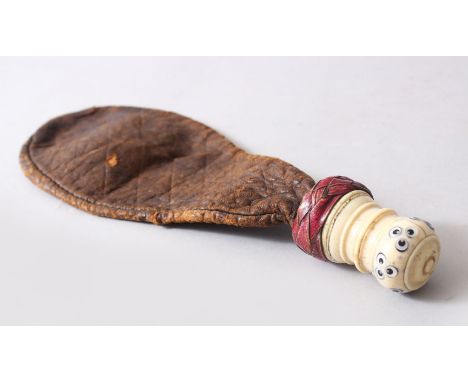 AN UNUSUAL POSSIBLY TURKISH OTTOMAN LEATHER POWDER FLASK, the carved bone handle with inlaid with mother of pearl roundel dec