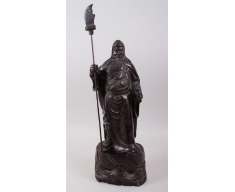 A GOOD 19TH / 20TH CENTURY CHINESE HARDWOOD HARVED FIGURE OF A BEARDED WARRIOR, stood on a tree formed base with foliage hold