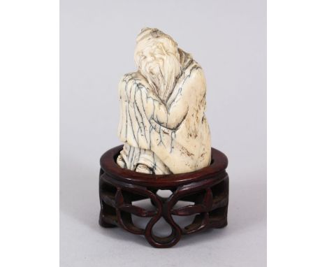 A GOOD 18TH CENTURY CHINESE CARVED IVORY FIGURE OF A BUDDHA / SAGE, in a crouched position with his face rest upon his knee, 