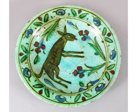 A 17TH CENTURY OTTOMAN IZNIK CERAMIC DEER DISH, the green / blue ground with floral decoration and a central deer, 24cm dia.