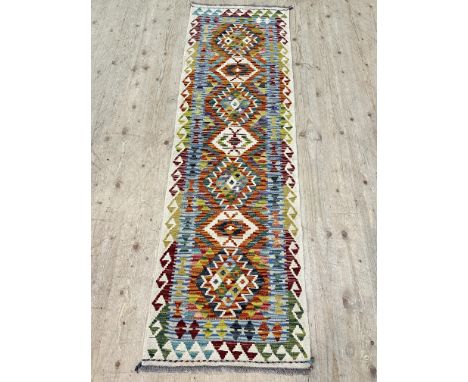 A chobi kilim runner, with colourful lozenge motifs encased with a cream border, 202cm x 60cm 
