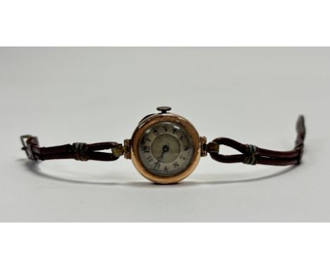 A vintage 9ct gold cased wristwatch with silvered dial and Arabic numerals on brown leather strap not working: d. x 2cm 16g