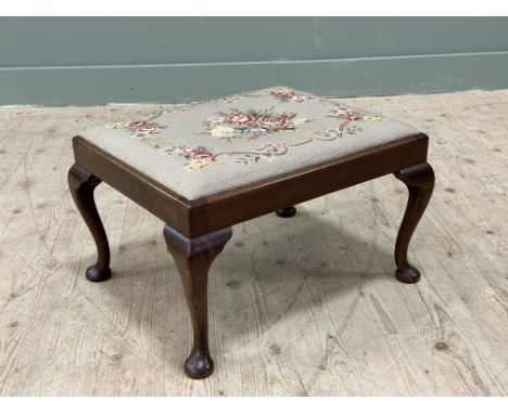 An Edwardian mahogany footrest with tapestry inset top, on cabriole supports (h.33cm x l.52cm x d.44cm)