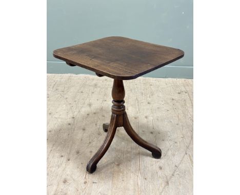 A 19thc mahogany snap top lamp table with square top and rounded angles, on turned baluster column and square scroll supports