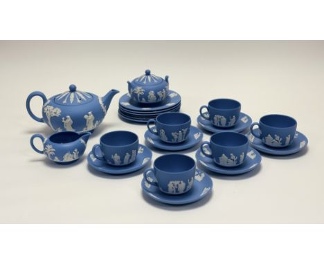 A Wedgwood blue Jasperware tea service with neoclassical scenes comprising, a teapot, sugar bowl with cover, milk jug (h-6cm)