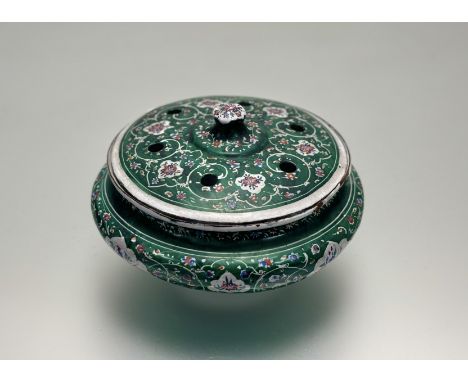 An eastern enamel incense dish with pierced top decorated with allover scrolling leaf and flower design with an emerald green