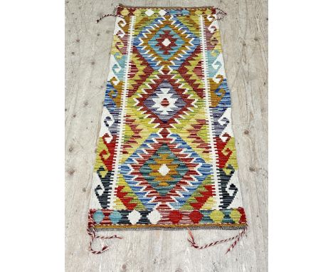 A chobi kilim runner, with colourful lozenge motifs encased with a multi coloured border, 144cm x 68cm 