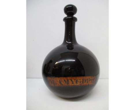 A 19th century dark purple glass drug flask of bulbous form with a cylindrical neck and bulbous stopper, inscribed OL Amygdpa