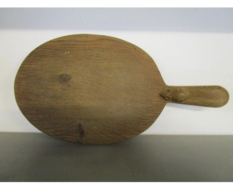 A Robert Thompson of Kilburn 1876-1955 - Mouseman, oak cheese board of oval form, carved signature mouse to handle, 15 3/8" l