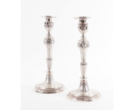 A PAIR OF GEORGE III SILVER TABLE CANDLESTICKSEach decorated with fluting to the stem on a fluted swept circular base, decora