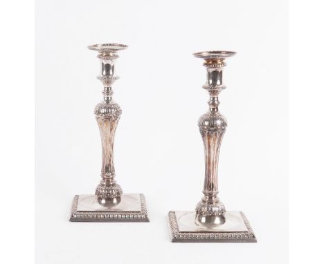 A PAIR OF GEORGE III CAST SILVER CANDLESTICKSEach with a tapered fluted stem below a foliate band above, raised on a square b