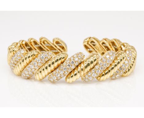 A GOLD AND DIAMOND CUFF BANGLEIn a rope design, with alternating pave set diamond sections and plain sections, would fit a 6 