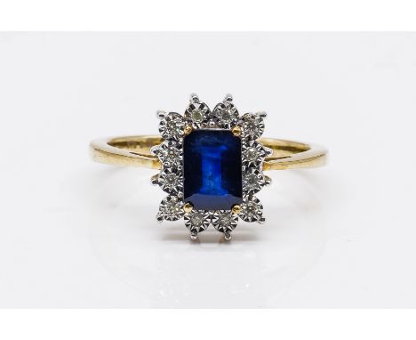 A GOLD, SAPPHIRE AND DIAMOND CLUSTER RINGClaw set with the cut cornered rectangular step cut sapphire, in a surround of circu