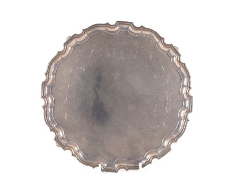 A SILVER SHAPED CIRCULAR SALVERHaving a pie-crust rim, in the Chippendale style, otherwise with engraved decoration, raised o