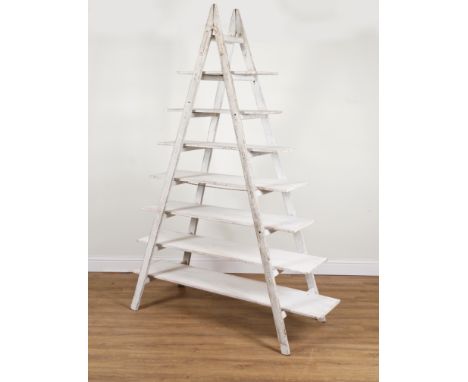 A SET OF SHELVES CONSTRUCTED FROM A PAINTED EIGHT RUNG A-FRAME STEP LADDER139cm wide; 49cm deep; 238cm high