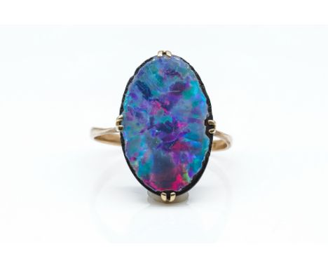 AN OPAL DOUBLET RINGClaw set, in 9ct gold, ring size M, weight 2.3 grams.